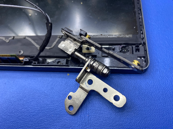 Vytrhnuté uchytenie pántu LCD veka notebooku pred opravou